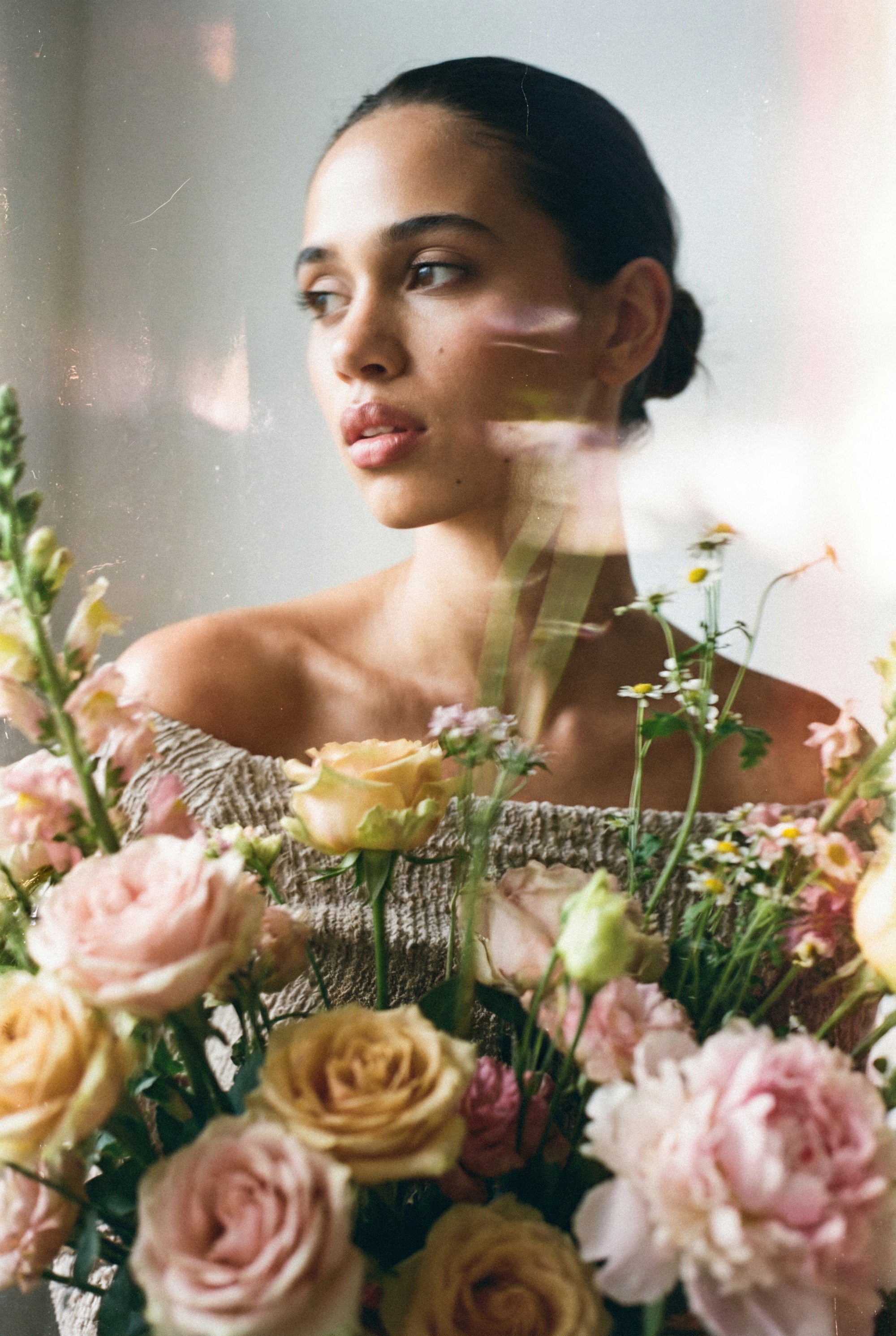 Femme entourée d'un bouquet de fleurs illustrant l’univers des cosmétiques naturels